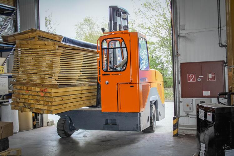 The HUBTEX DQ passing through a gate carrying a bulky load of wood